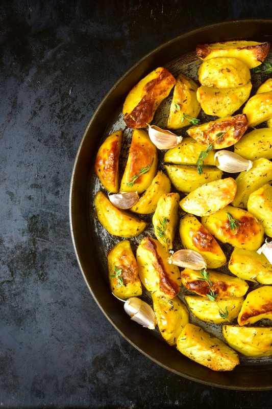 Crispy Roasted Potatoes in a round dish with garlic 