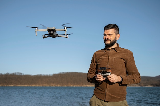 medium-shot-smiley-man-with-drone-outdoors_23-2149392703