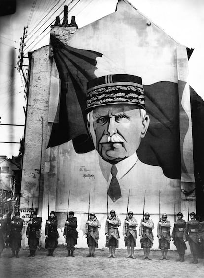 Una parada militar delante de un mural con el retrato del mariscal Petain en Vichy durante la Segunda Guerra Mundial