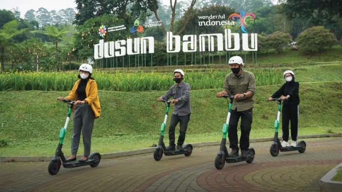 Pengunjung Dusun Bambu sedang mencoba aktivitas e-scooter saat berwisata.
