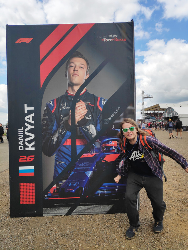 Chris posing in front of a Daniil Kvyat poster