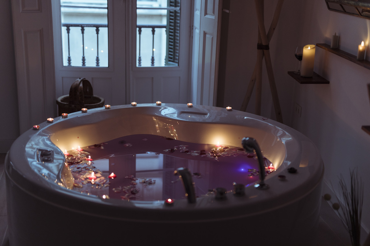 flower petals water spa tub with burning candles edges