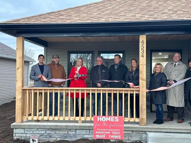 A single-family home with beige siding, white trim, and a two-car garage