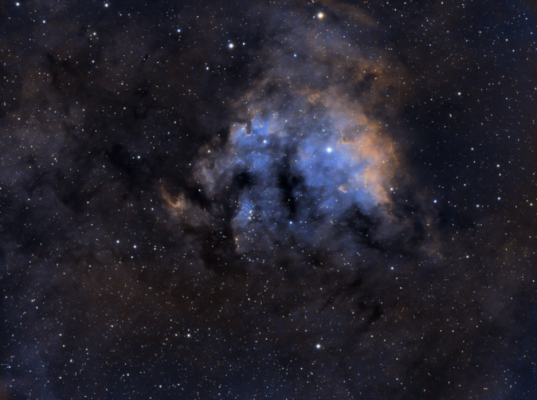 Nebulosa NGC 7822 en paleta SHO (Hubble Palette) mostrando estructuras gaseosas en tonos rojos, dorados y azules