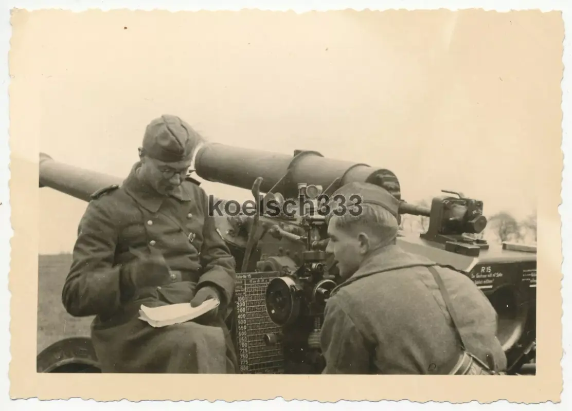 Foto Kanoniere an schwerer Feldhaubitze mit Mündungsbremse in Feuerstellung