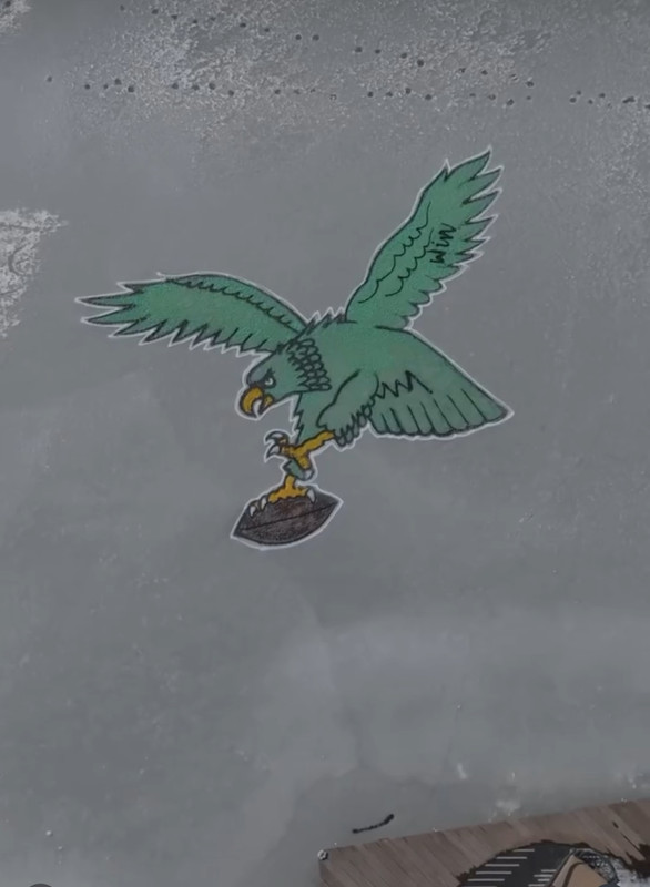 A close-up shot of a custom Philadelphia Phillies logo spray-painted on a lawn.