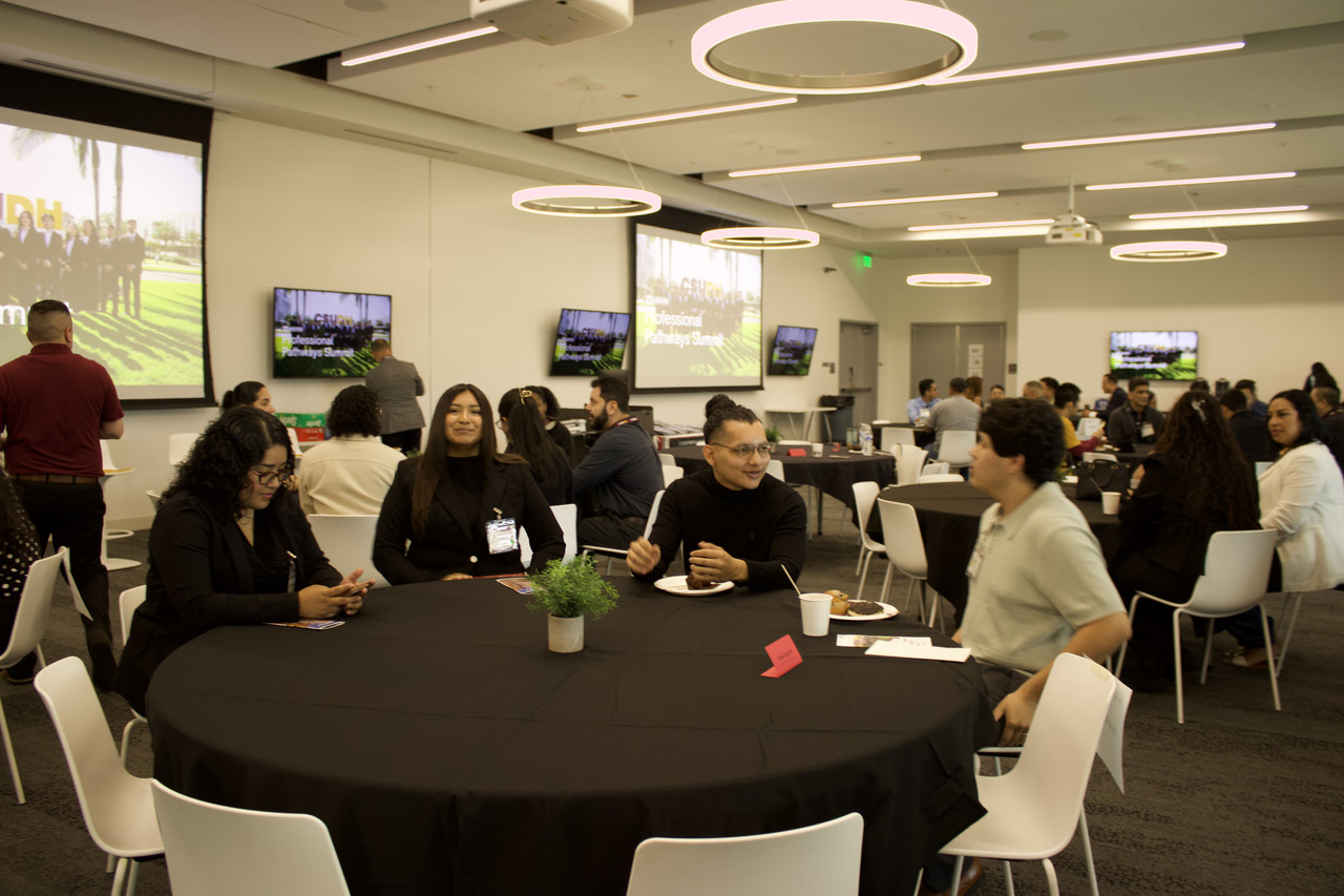 Students networking around a round table.