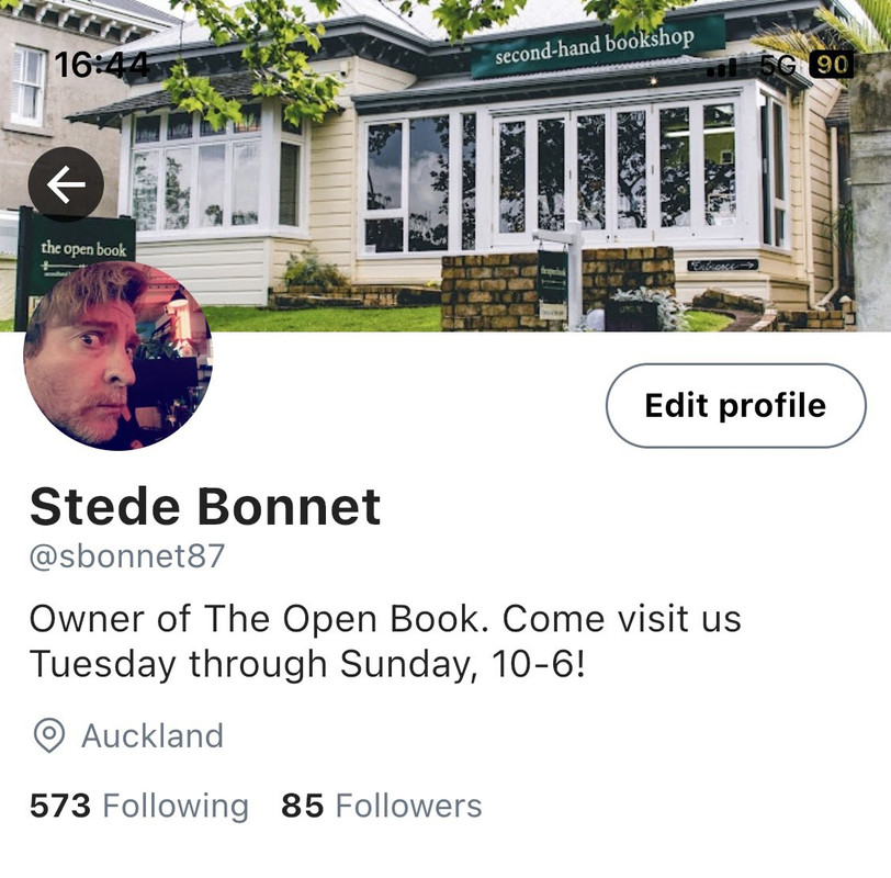 Twitter profile for @sbonnet87, Stede Bonnet. Profile reads “Owner of The Open Book. Come visit us Tuesday through Sunday, 10-6!” Located in Auckland, Following 573, Followed by 85