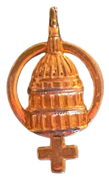 a gold enamel pin of the 'female' symbol with the state capitol building in the center