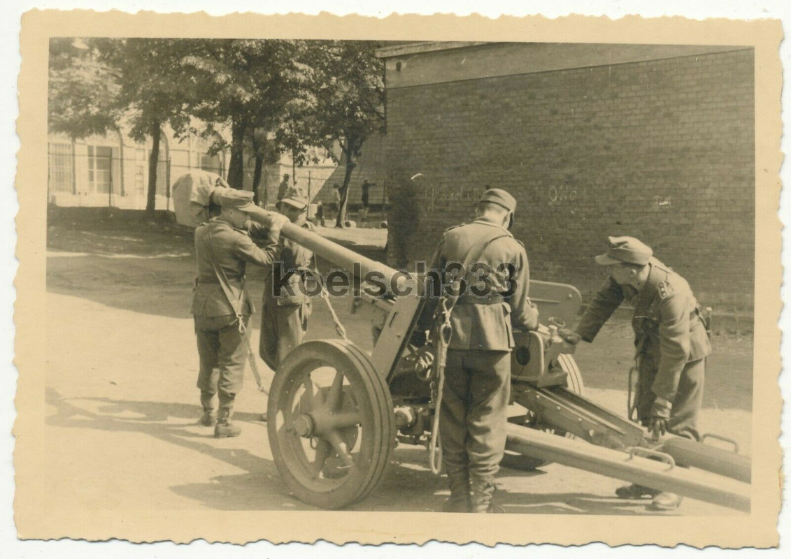 Foto Panzerjäger der Wehrmacht mit Feldmützen an einem 7,5cm PaK Geschütz