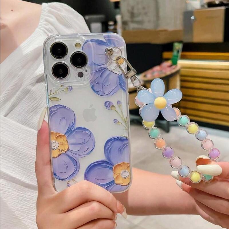 Foto de Funda transparente con diseño flora. Incluye correa de mano.