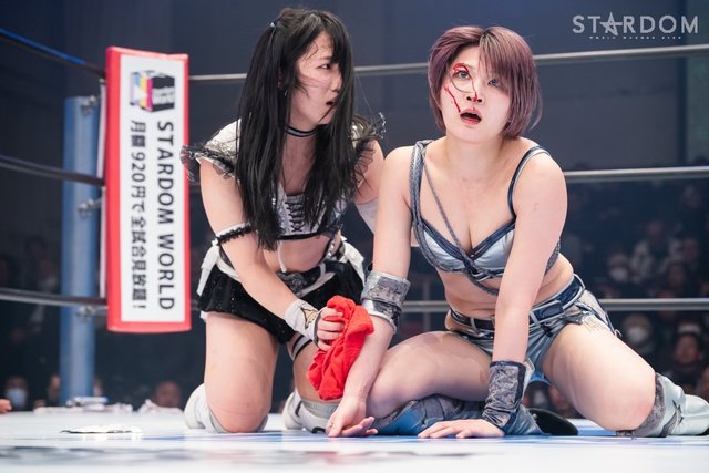 Photo from STARDOM of Saori Anou bleeding from right eyebrow as Kurara checks on her