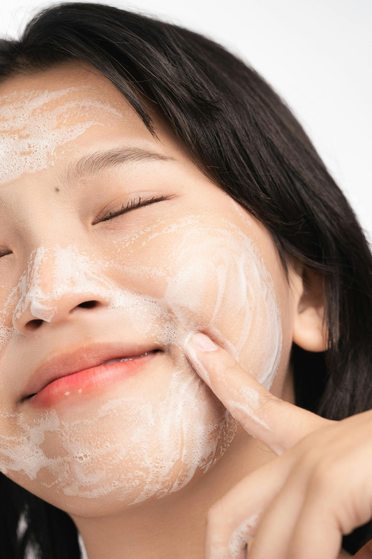 A close-up of a skincare product application showing glowing, healthy skin.