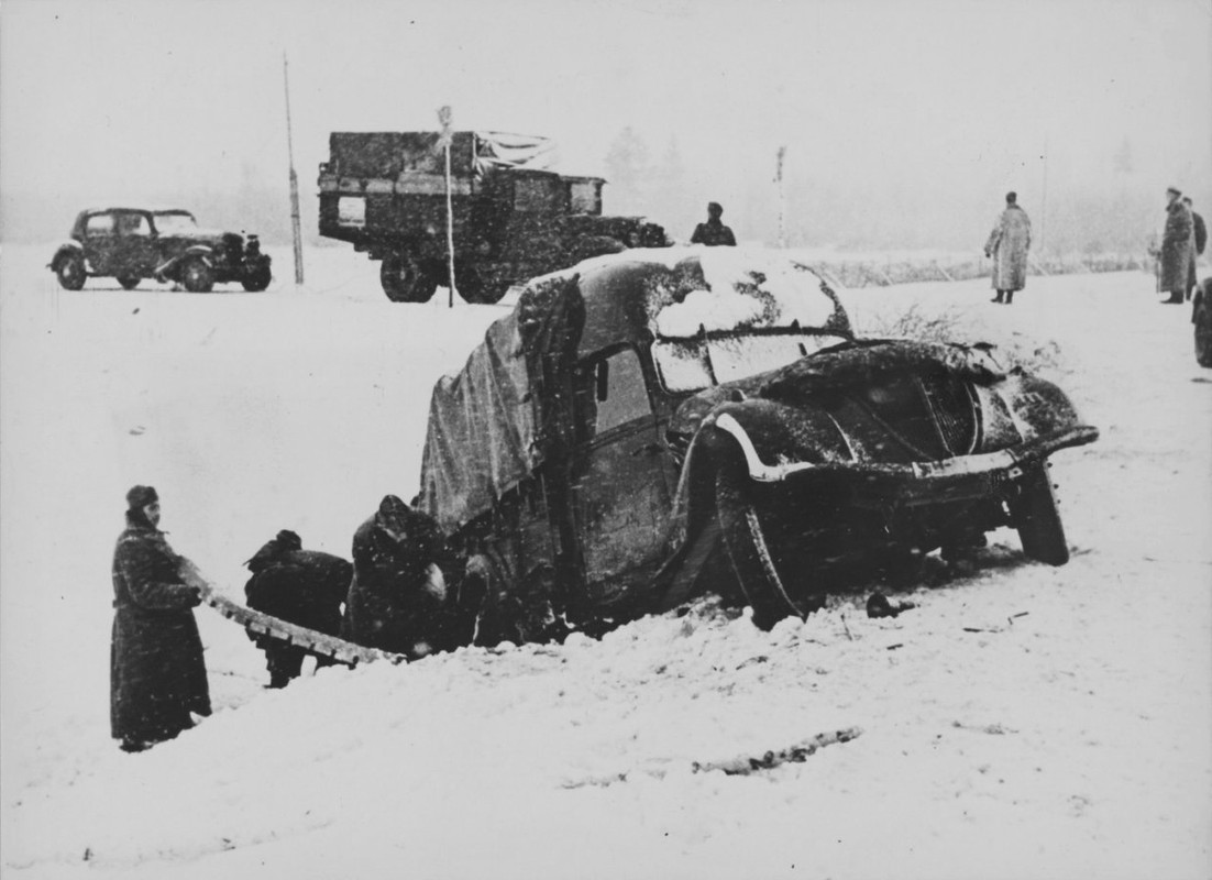 Немецкие солдаты выталкивают застрявший трофейный автомобиль Пежо DK5 французского производства на д