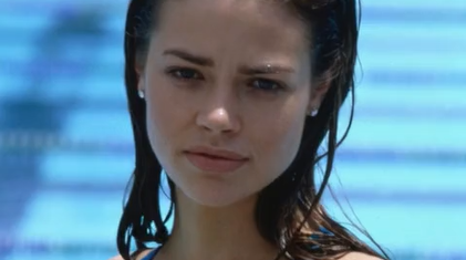 A Hot Chick Standing In A Blue Dress, Teasing With Her Deep Cleavage.