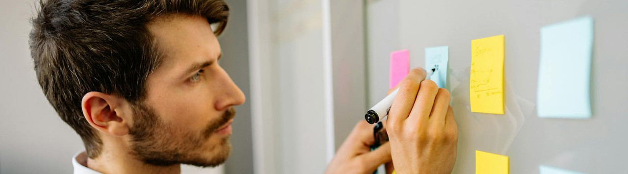 A man writing on sticky notes