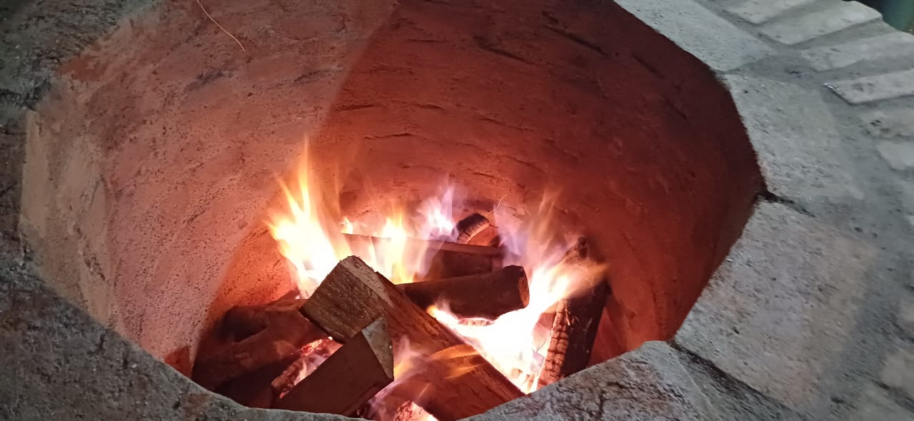 Fuego y leña de encino en el horno de piedra