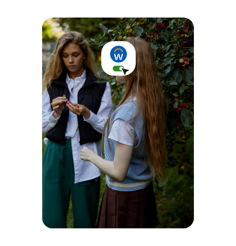 Two women posing at an office work area with warm color tones 1