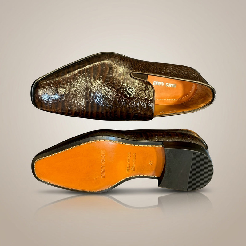 Chestnut brown Chelsea boots with elastic side panels on stone surface