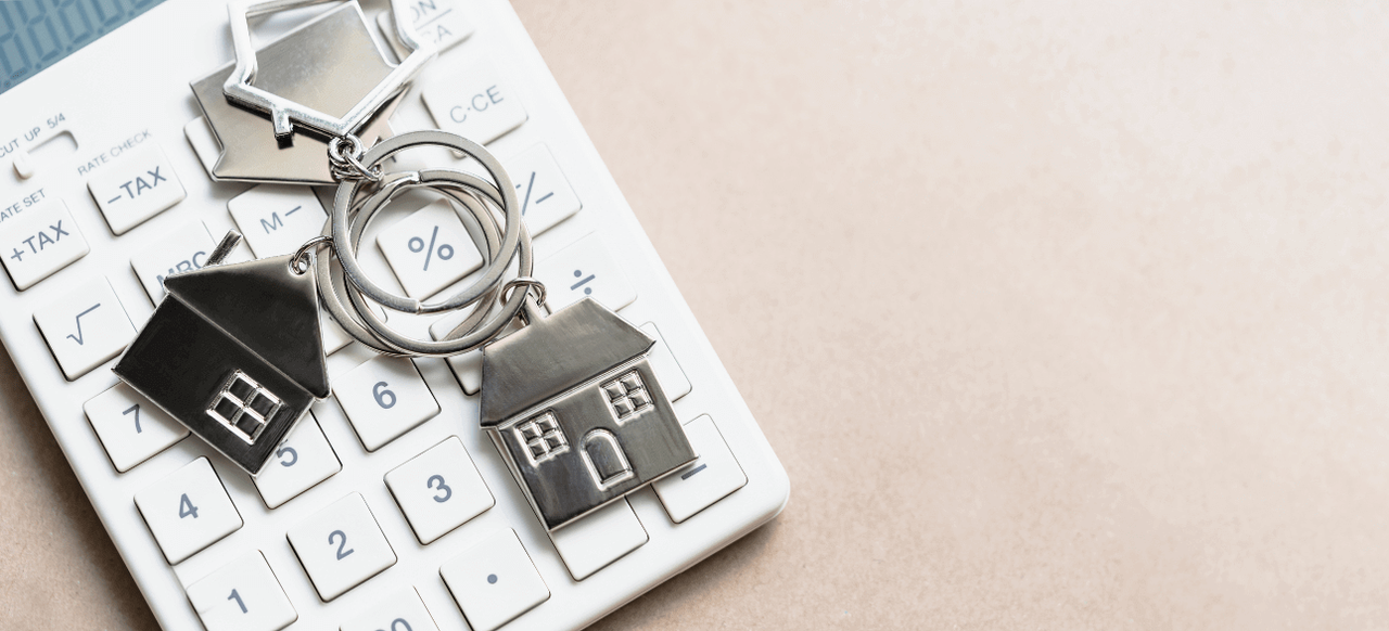 small house on keychain laying beside calculator
