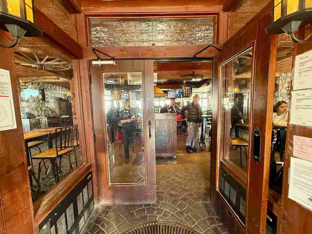 Interior view of La Forge restaurant in Mont Tremblant with wooden decor and wine glasses on the table.
