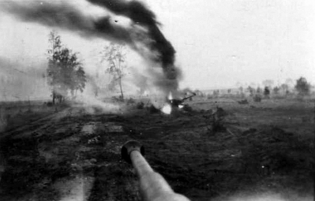 Vista desde la torreta de un Tiger, un T-34 arde en llamas a un lado del camino