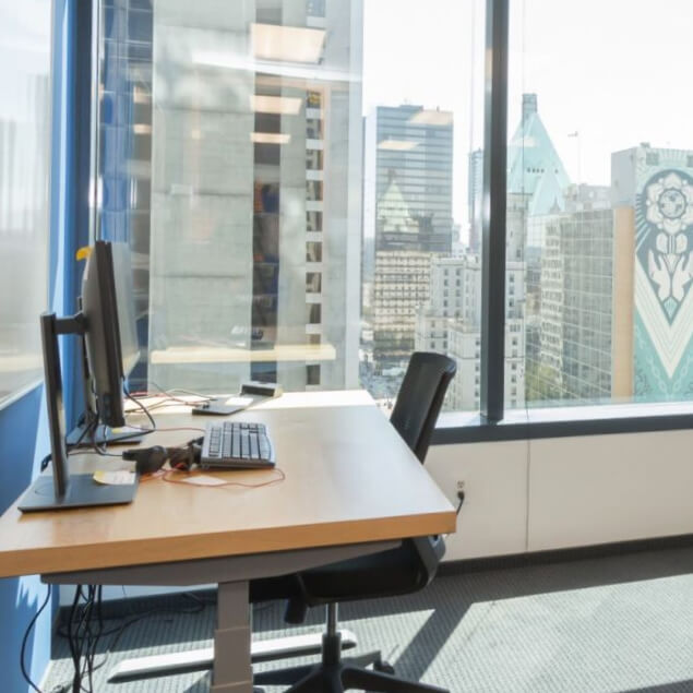 Private office desk positioned at window in brightly lit room