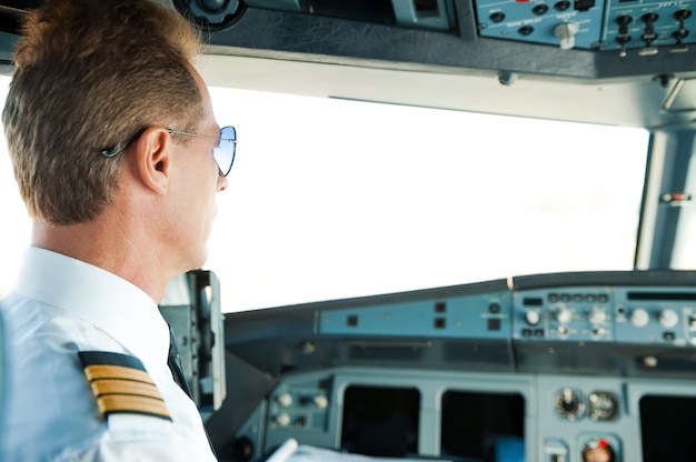 getting-ready-flight-rear-view-confident-male-pilot-sitting-airplane-cockpit