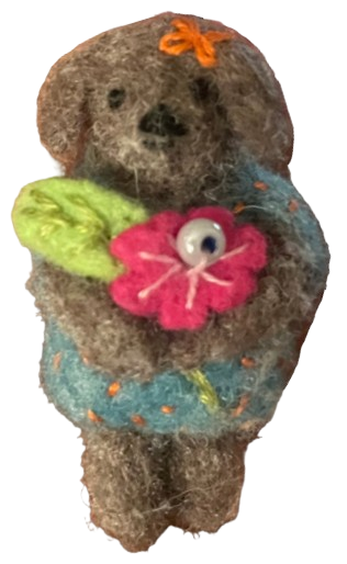 a pin of a little felt animal [koala? bear? dog?] in a blue dress, holding a pink flower with a leaf, and an orange bow on its head