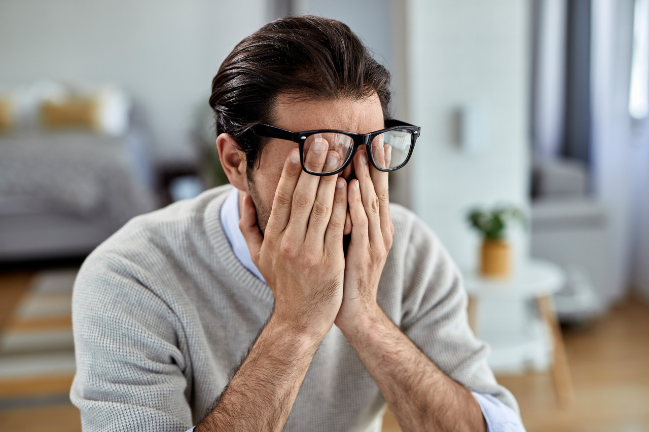 young businessman feeling exhausted while working home