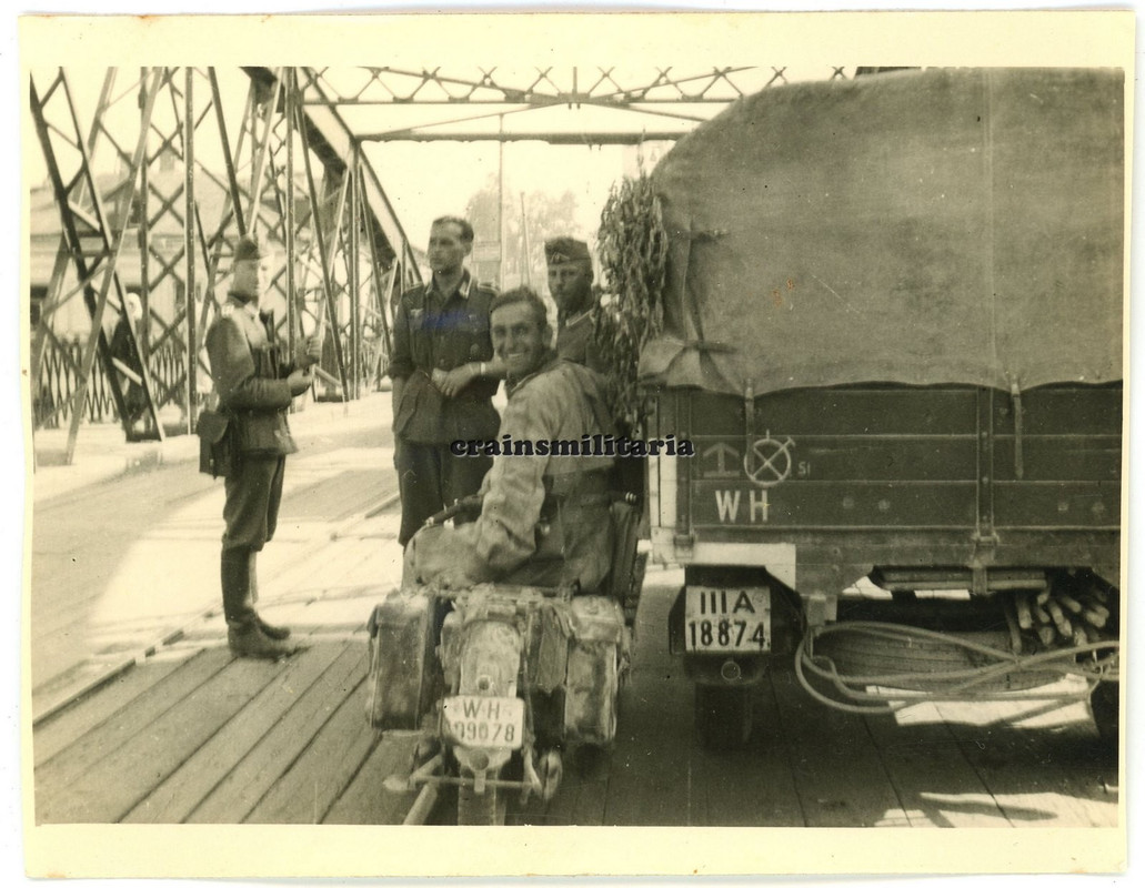 Orig. Foto Heer Kradmelder mit Motorrad bei Lkw mit Wappen auf Brücke