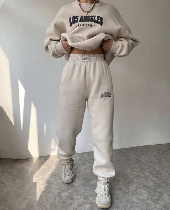 Дівчина у стильному жіночому спортивному костюмі для активного відпочинку та прогулянок