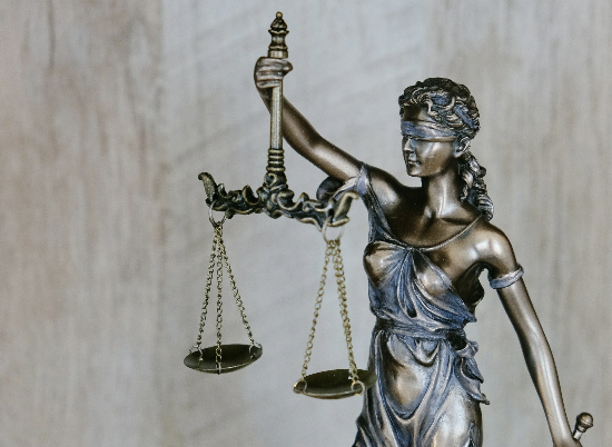 Bronze sculpture of blindfolded Lady Justice with scales and sword