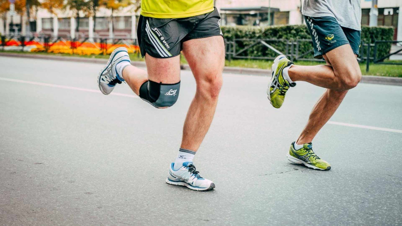 5 nguyên nhân đau đầu gối khi chạy bộ - runner mang đai bảo vệ gối chạy trên mặt đường nhựa cứng