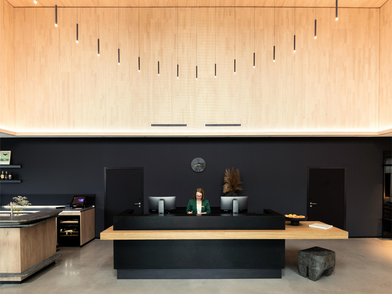 Coreum Hotel reception with circular chandelier creating a focal lighting layer within the double-height lobby