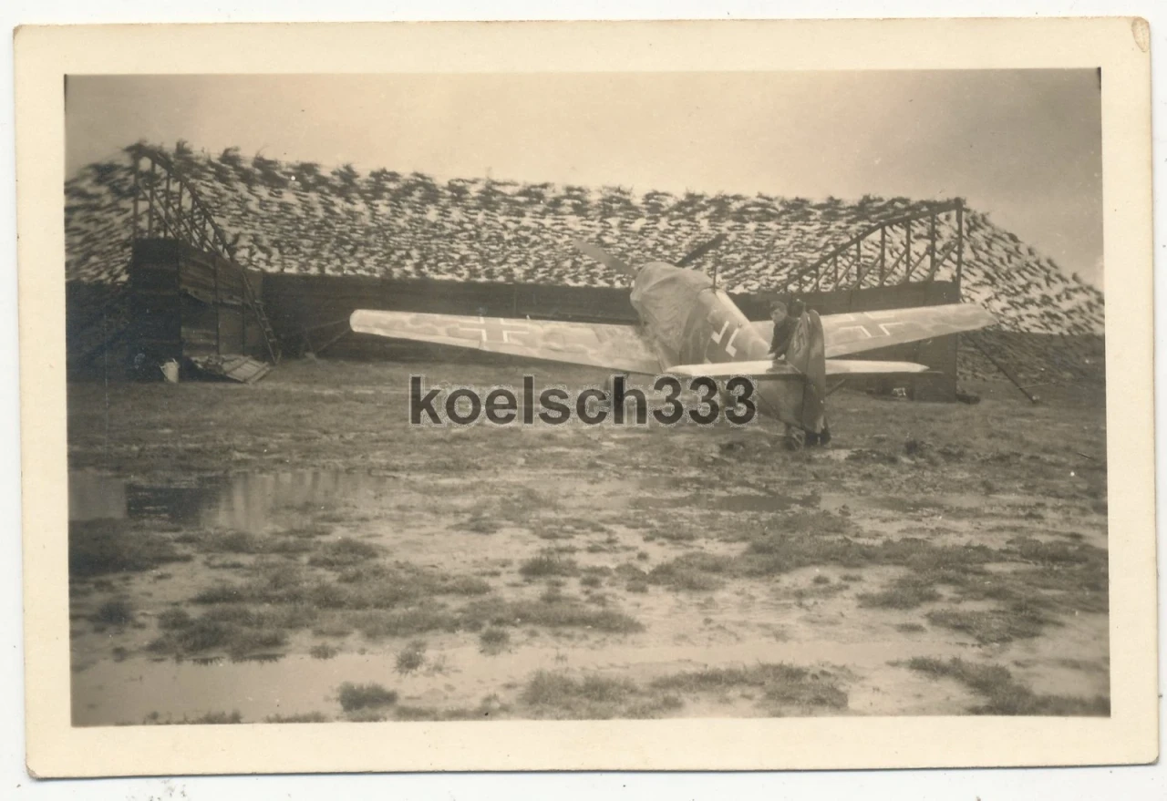 Foto Messerschmitt Bf 109 Flugzeug vor einer Box mit Tarnnetz 2 Erg Gr JG 27