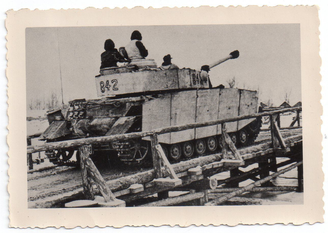 Panzer im Wintertarnanstrich fährt über eine Beh