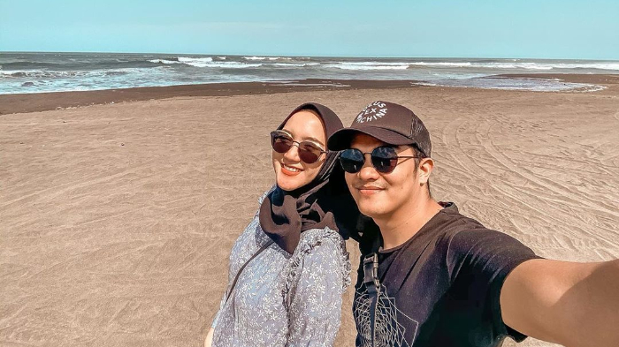 Erica Putri dan sang suami tengah berlibur di pantai.