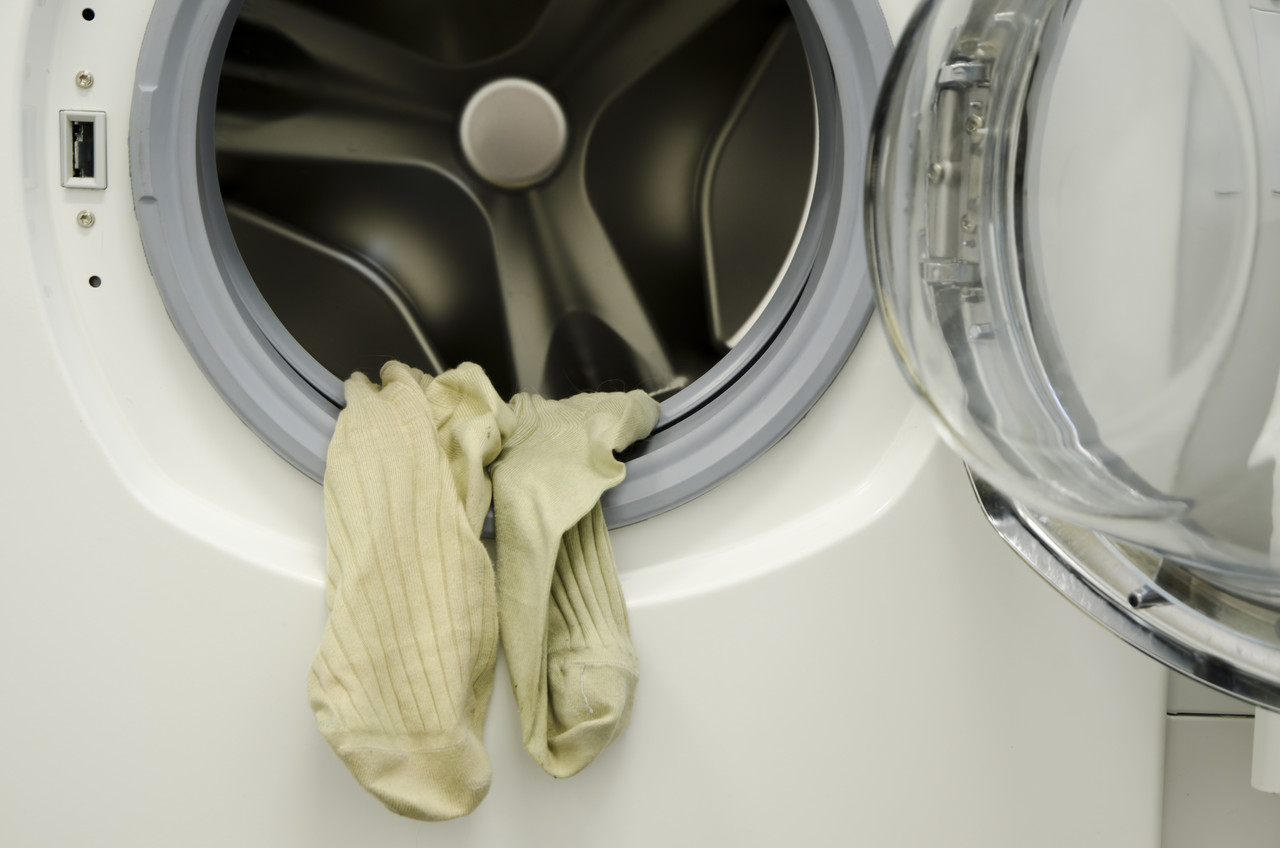 closeup shot dirty laundry hanging from washing machine