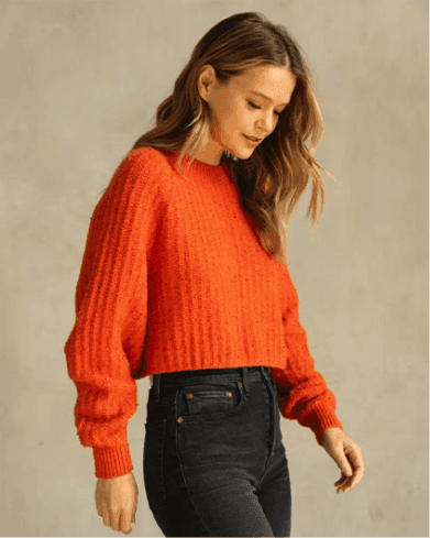 Picture of female model with orange knit sweater