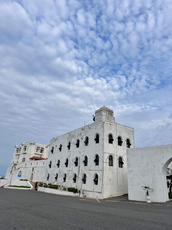 White colonial-era castle with arched windows on the Ghanaian coast