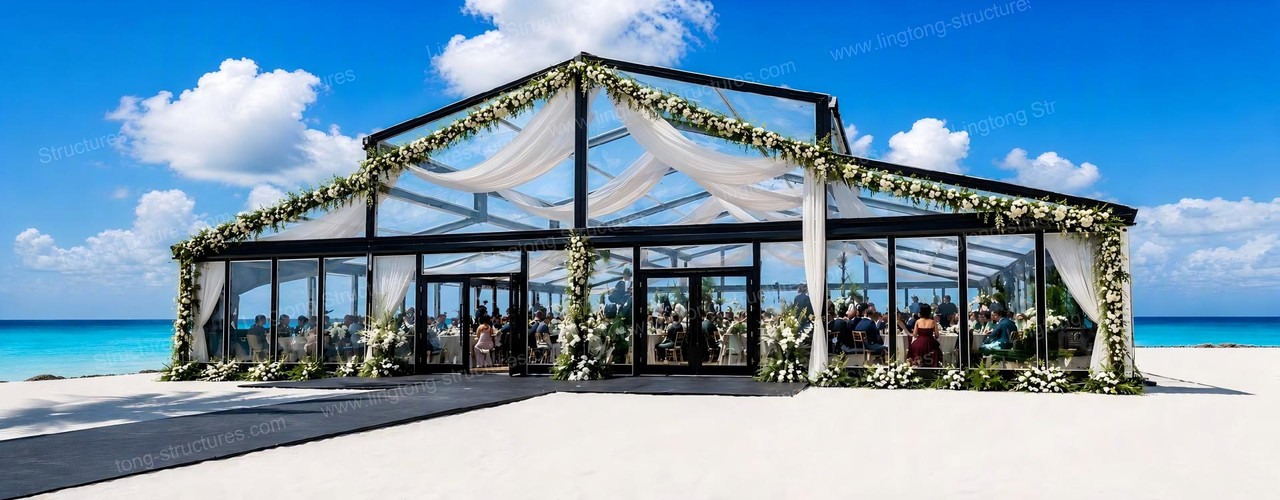 Atrium wedding tent with transparent glass walls and roof in a garden setting