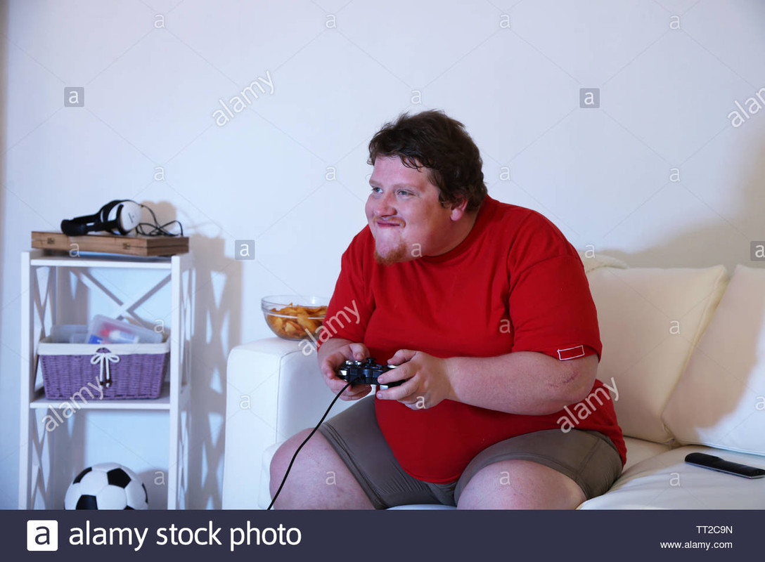 fat-man-playing-video-games-on-home-interior-background-TT2C9N