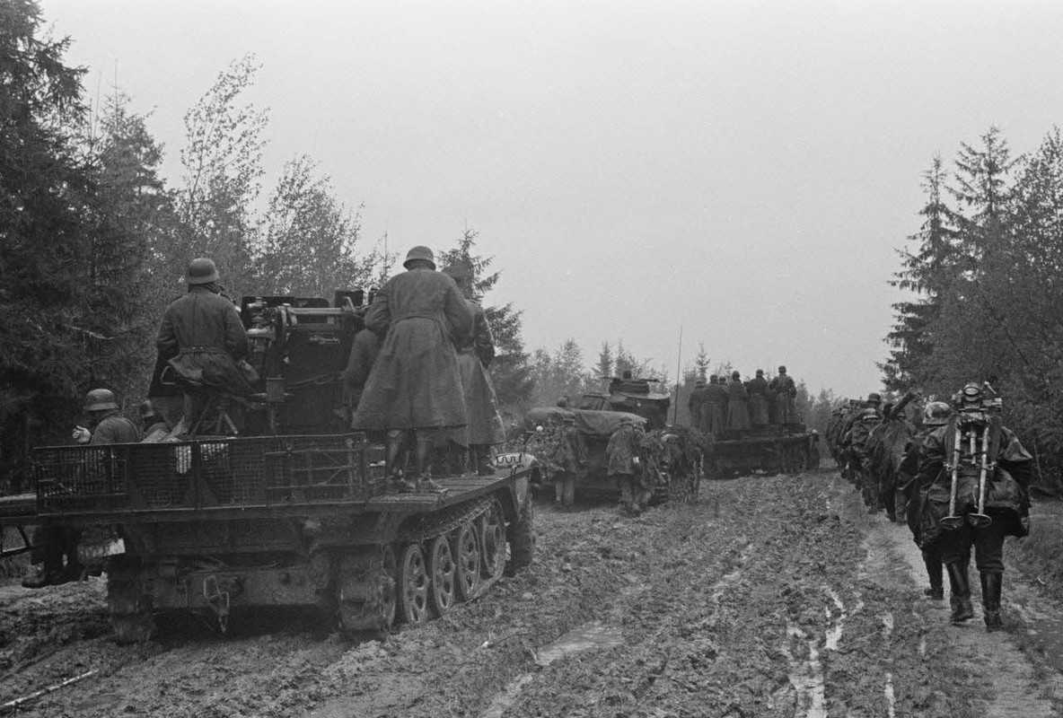La progression de fantassins allemands soutenus par des blindés Panzer-III et un semi-chenillé Sd.kf