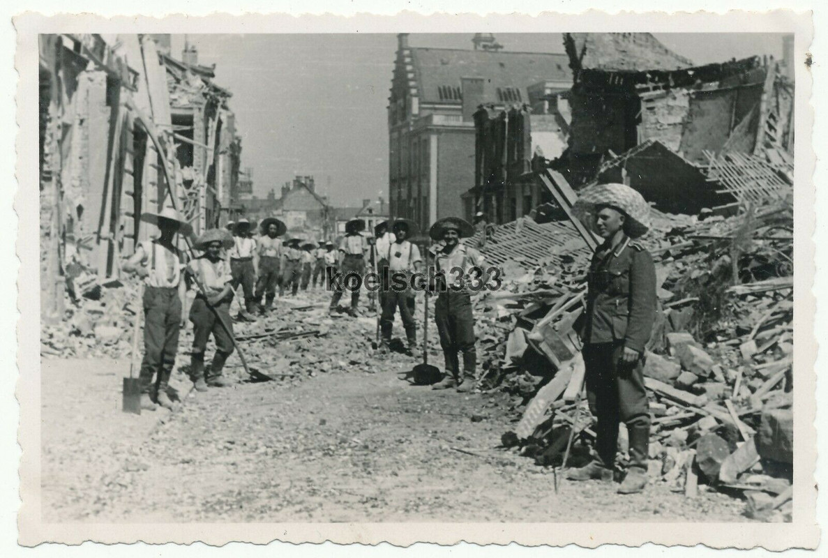 Foto Soldaten der Wehrmacht mit Strohhüten in den Ruinen von Nesle Frankreich