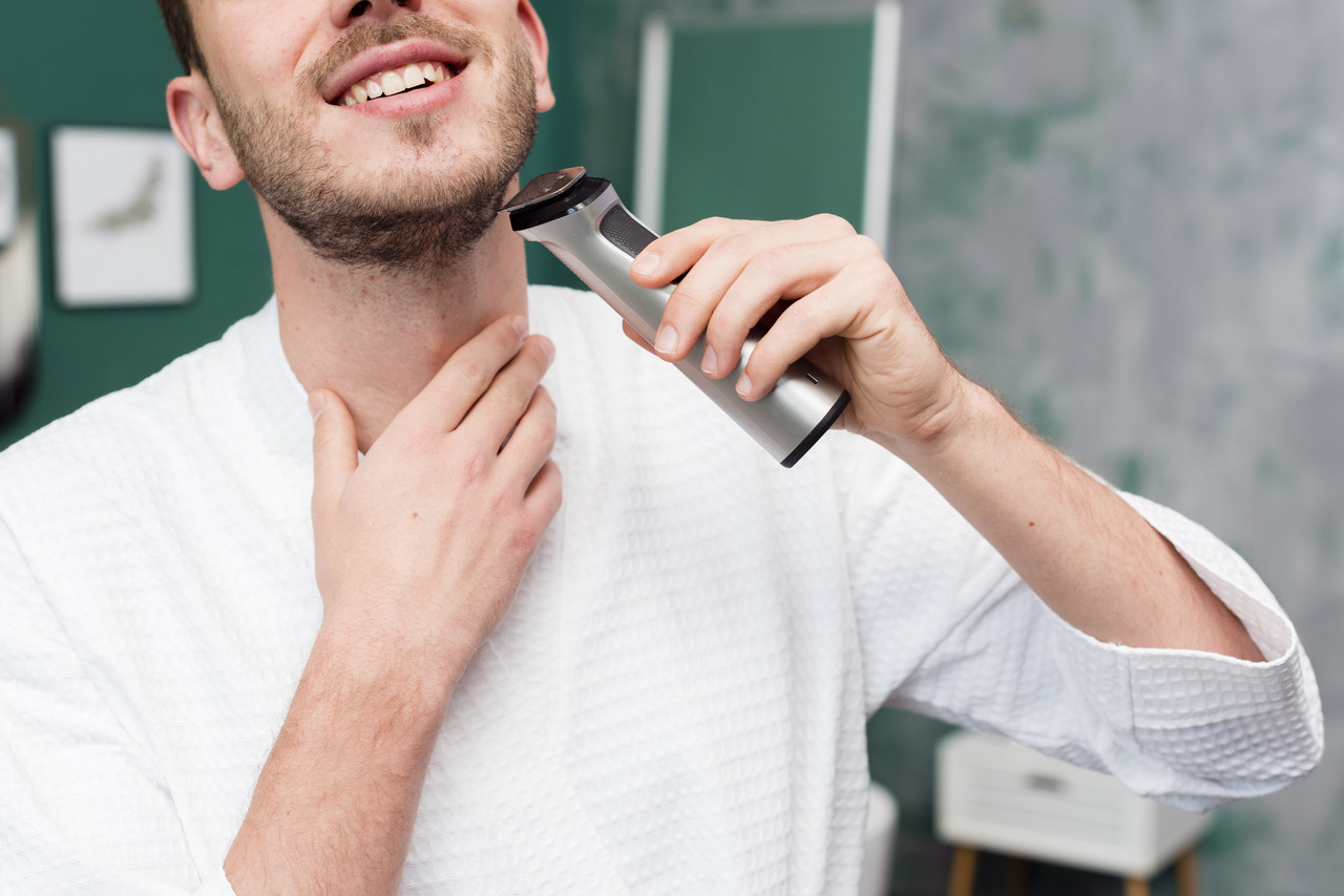 front view man bathrobe using trimmer