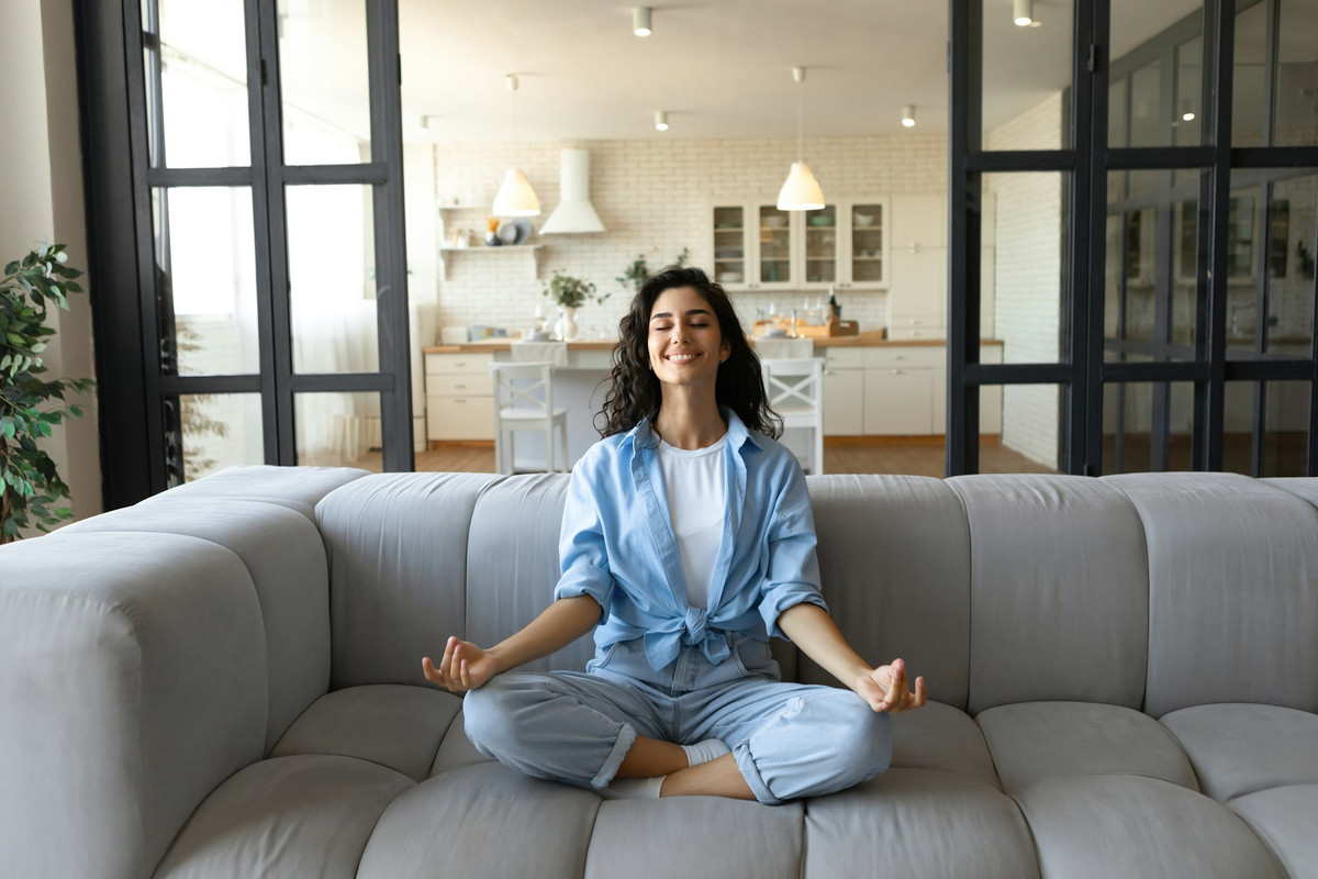 stress-management-peaceful-young-lady-in-casual-wear-meditating-with-closed-eyes-on-couch-at-home.jpg