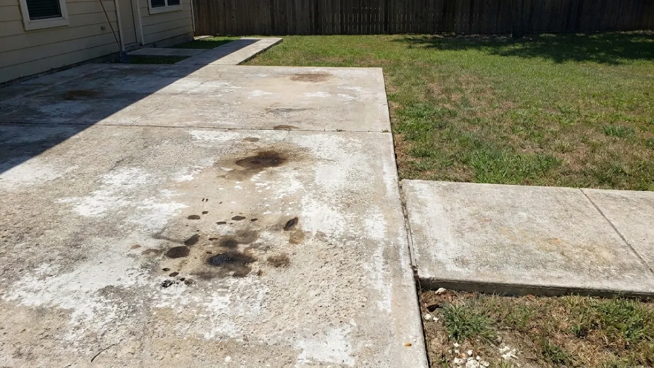 Weathered and sun-faded concrete patio in San Antonio TX showing chalky surface color loss and worn texture from UV exposure and missing sealer