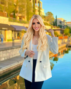 Chanel Cazzaniga, a very beautiful blonde woman with blue eyes, dressed in a white blazer an