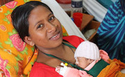 Kangaroo Mother Care (KMC) - skin-to-skin contact, baby in upright prone position between mother's breasts, covered with cloth, using a wrap or sling